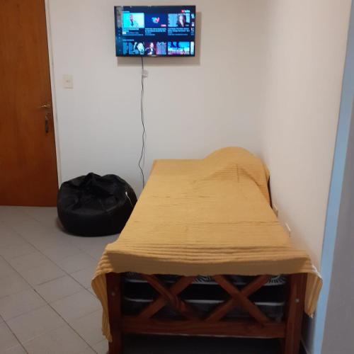 Habitación con mesa y TV en la pared. en Departamento Villanueva en Godoy Cruz