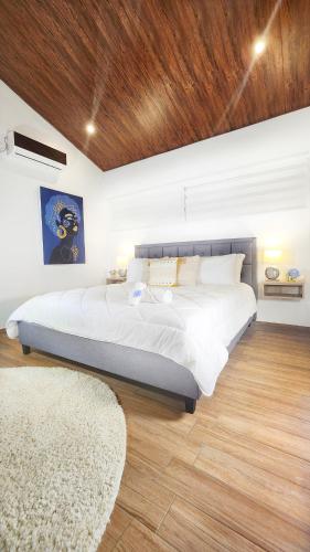 a bedroom with a large bed with a wooden ceiling at Rio Verde by Villa Alejandro in Boquete