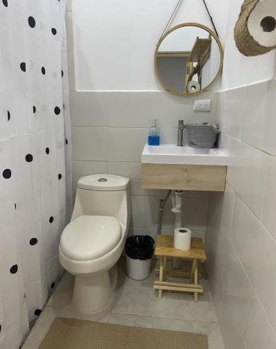 a bathroom with a toilet and a sink and a mirror at LOOKING2GOOD in El Zonte