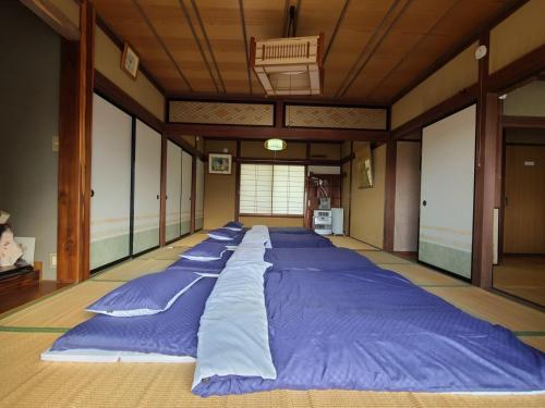 東御市にあるゲストハウス陽だまりの宿の青い枕が備わる客室の大型ベッド1台