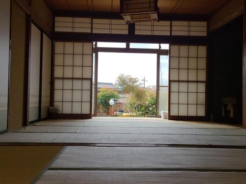 an empty room with a large window in a building at ゲストハウス陽だまりの宿 in Tomi