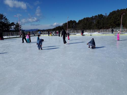 a group of children playing on an ice rink at ゲストハウス陽だまりの宿 in Tomi