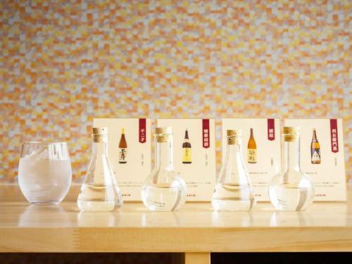 four empty wine bottles sitting on a table with a glass at Iseebisou in Ibusuki