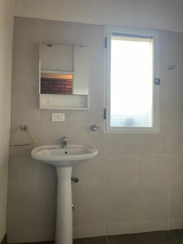 a bathroom with a sink and a window at Andes cerros departamento en mendoza ciudad in El Challao