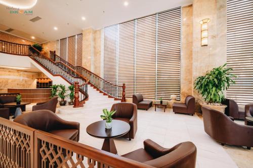 a lobby with a staircase and chairs and tables at Ha Long Dream Hotel in Ha Long