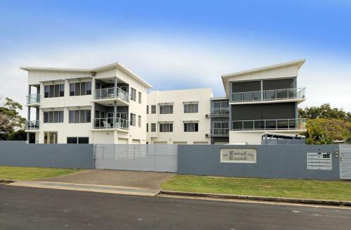 a white building with a fence in front of it at Beach Break in Bargara