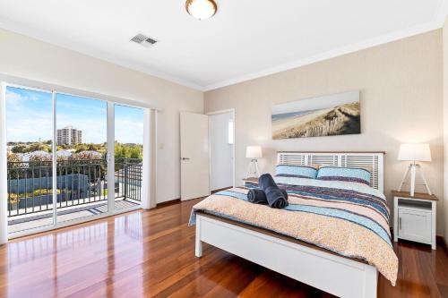 a bedroom with a bed and a large window at Beachfront Family Favourite Home with Pool & Views in Mandurah
