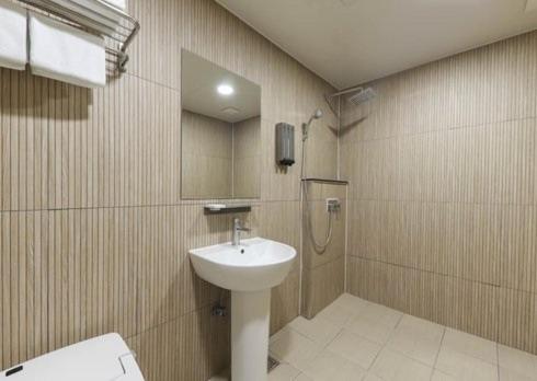 a bathroom with a sink and a shower at Gwangju Brown Dot Chungjang in Gwangju