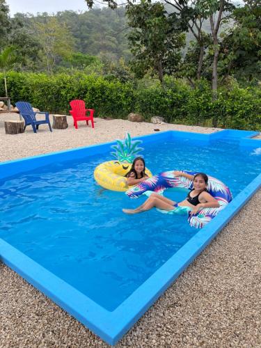 dos chicas están acostadas en una piscina inflable en Barcaza de 2 habitaciones a 2 km de Playa Potrero, en Potrero