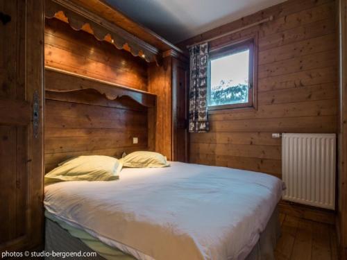 アーク 1801にあるAppartement Les Arcs 1800, 2 pièces, 4 personnes - FR-1-352-11の木製の部屋に大型ベッドが備わるベッドルーム1室が備わります。