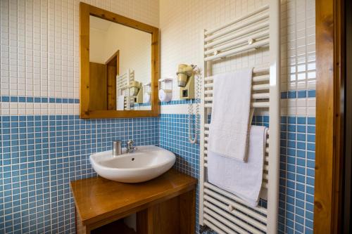 uma casa de banho em azulejos azuis com um lavatório e um espelho em Casa das Arribas - Rio Douro aos seus pés na Bemposta