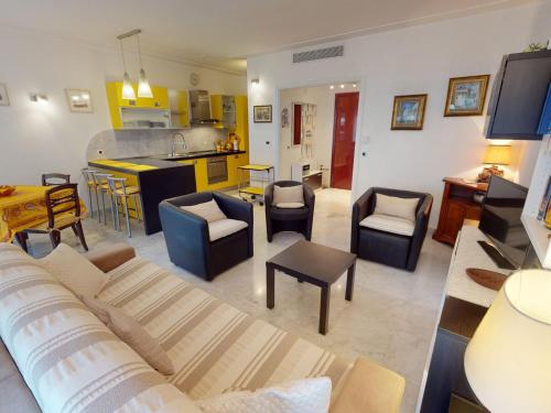 un salon avec un canapé et des chaises et une cuisine dans l'établissement Grand 2 pièces climatisé avec terrasse et garage privé près de la mer - FR-1-196-311, à Menton