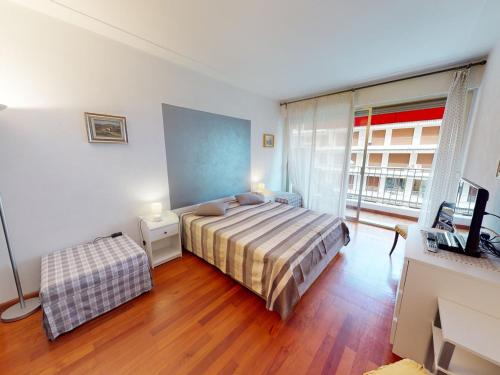 une chambre avec un lit et une télévision dans l'établissement Grand 2 pièces climatisé avec terrasse et garage privé près de la mer - FR-1-196-311, à Menton