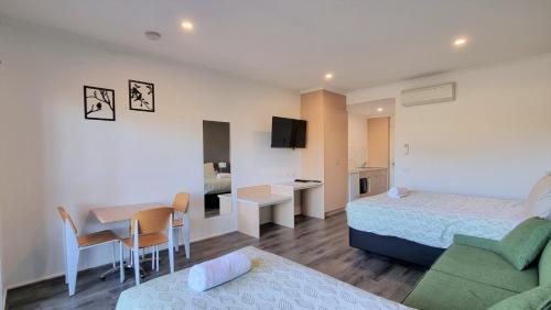 a hotel room with a bed and a table and a chair at Seaview Motel & Apartments in Apollo Bay