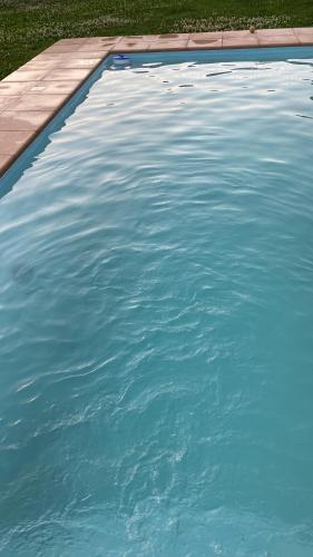 una piscina de agua azul en un patio en Monoambiente El Pinar Parque y Pileta Privada en San Luis