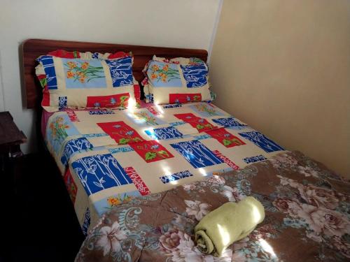 a bed with a blanket and pillows on it at Reviva Residence in Blue Bay