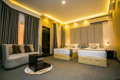 ein Hotelzimmer mit zwei Betten und einer Couch in der Unterkunft Tropical Daisy - Lake View in Dhaka