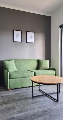 a living room with a green couch and a coffee table at Seaview Motel & Apartments in Apollo Bay
