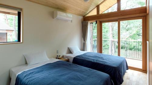 Duas camas num quarto com uma janela em PICA Yamanakako Village em Yamanakako
