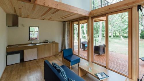a living room with a blue couch and a kitchen at PICA Yamanakako Village in Yamanakako
