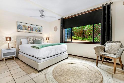 a bedroom with a bed and a window and a chair at A Family Home Away From Home in Gold Coast