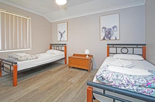 a room with two beds and a table in it at Boronia 4x2 in Jurien Bay