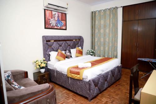 - une chambre avec un lit, un canapé et une chaise dans l'établissement Fortune Home Service Apartment 3Bhk,E-28 Saket 1B, à New Delhi