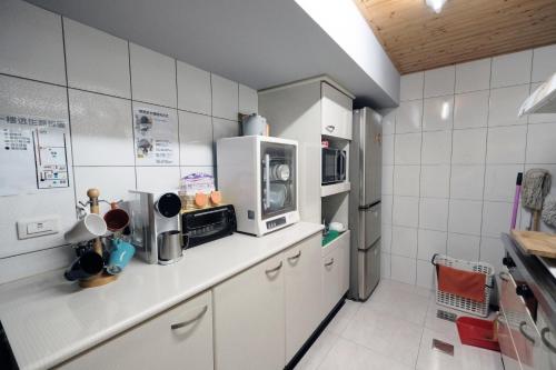安平的住宿－安平九十八巷，厨房配有白色橱柜和微波炉