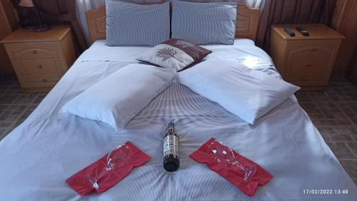 a white bed with white pillows and red pants on it at La Petri Studios with Fireplace & View in Metsovo