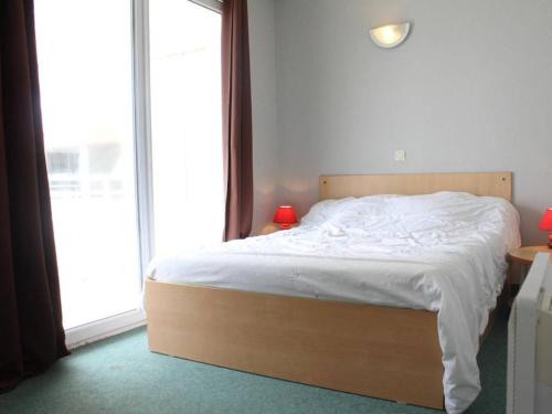 Schlafzimmer mit einem Bett mit weißer Bettwäsche und einem Fenster in der Unterkunft Appartement La Rochelle, 2 pièces, 4 personnes - FR-1-246-11 in La Rochelle