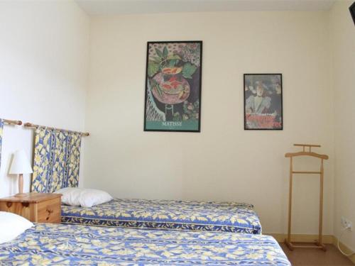 ラ・ロシェルにあるAppartement La Rochelle, 1 pièce, 2 personnes - FR-1-246-95のベッドルーム1室(ベッド2台付)が備わります。壁に2枚の写真が飾られています。