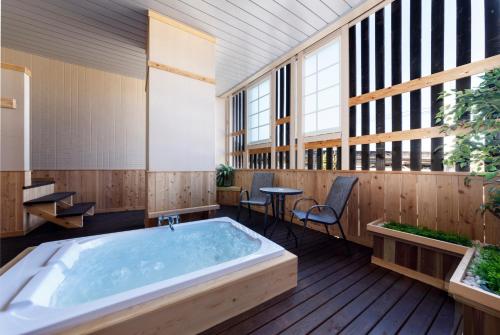 uma banheira de hidromassagem num quarto amplo com janelas em HOTEL HanaBi 長良の湯 -大人専用- em Gifu