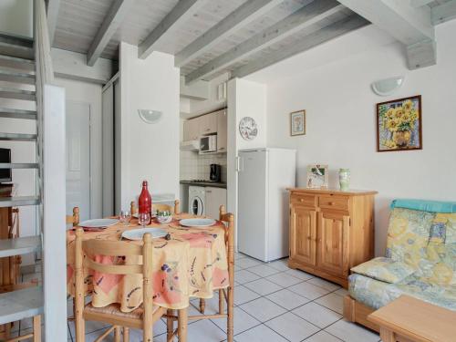 une cuisine et une salle à manger avec une table et un réfrigérateur dans l'établissement Duplex 3 Pièces 6 Pers., Terrasse, Calme, Proche Centre - FR-1-402-93, à Esquièze - Sère
