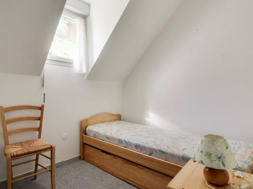 une petite chambre avec un lit et une chaise dans l'établissement Duplex 3 Pièces 6 Pers., Terrasse, Calme, Proche Centre - FR-1-402-93, à Esquièze - Sère