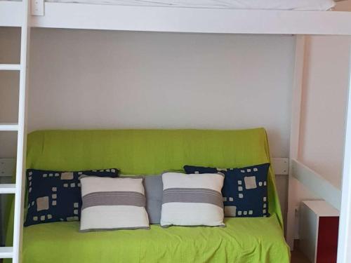 - un lit superposé vert avec des oreillers dans la chambre dans l'établissement Appartement T2 à Cauterets, proche centre, parking et box inclus, idéal pour 5 personnes - FR-1-234-237, à Cauterets