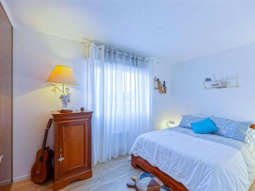 a bedroom with a bed and a lamp and a guitar at Appartement Bayonne, 2 pièces, 2 personnes - FR-1-3-538 in Bayonne