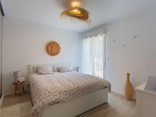 a white bedroom with a bed and a window at Appartement Saint-Jean-de-Luz, 2 pièces, 4 personnes - FR-1-4-617 in Saint-Jean-de-Luz