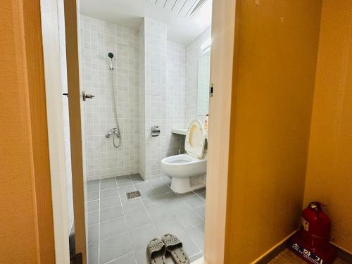 a white bathroom with a toilet and a shower at Olive hostel R(Residence) in Seoul
