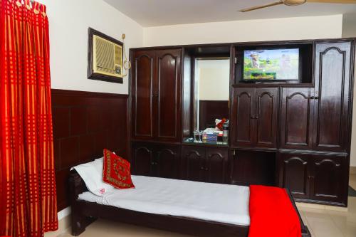a bedroom with a bed and a tv in a cabinet at Ali International Hotel in Dhaka