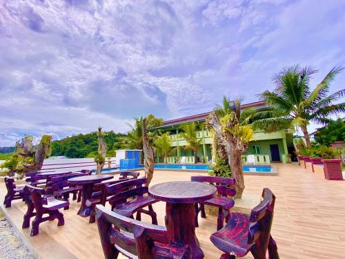 a group of tables and chairs on a patio at Cenang Room Rahsia Motel in Pantai Cenang