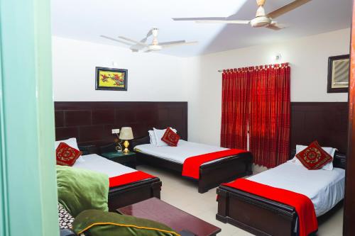 a bedroom with two beds with red and green sheets at Ali International Hotel in Dhaka