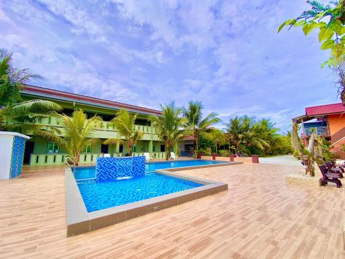 un complexe avec une piscine en face d'un bâtiment dans l'établissement Cenang Room Rahsia Motel, à Pantai Cenang