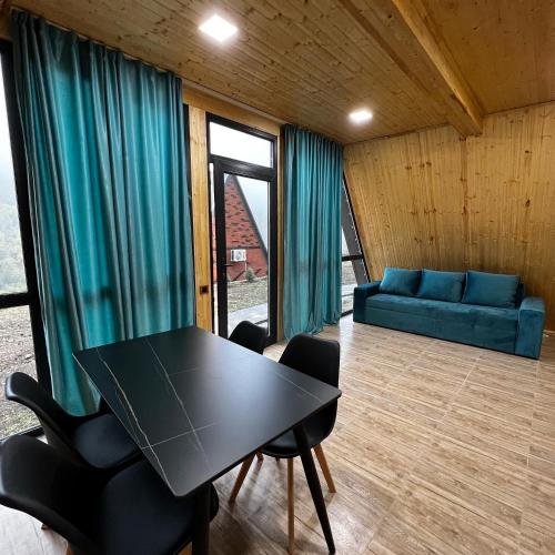 Habitación con mesa, sillas y sofá en Green Villa Resort Light Blue, en Dilijan