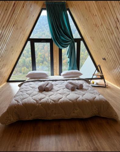 um quarto com uma cama em frente a uma grande janela em Green Villa Resort Light Blue em Dilijan