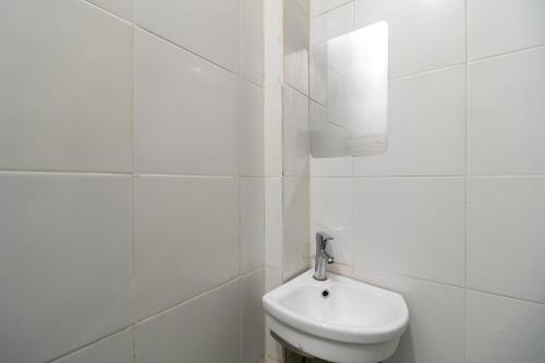 a white bathroom with a toilet and a sink at Urbanview Hotel Bizhome Artha Gading Boulevard by RedDoorz in Jakarta