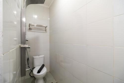 een witte badkamer met een toilet in een kamer bij Urbanview Hotel Bizhome Artha Gading Boulevard by RedDoorz in Jakarta