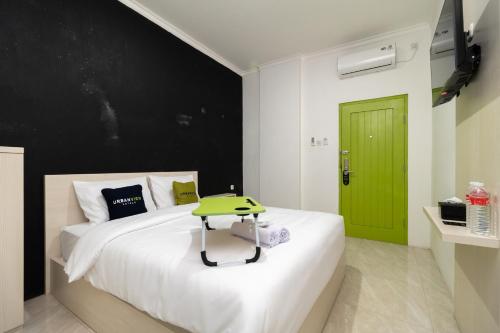 een slaapkamer met een groot wit bed en een groene deur bij Urbanview Hotel Bizhome Artha Gading Boulevard by RedDoorz in Jakarta