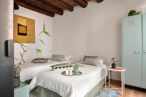 two beds in a room with white walls at Venice Parsley in Venice