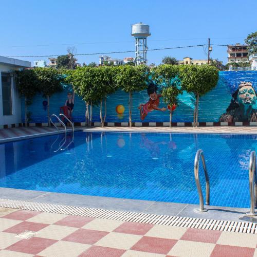 a swimming pool with people jumping in the water at Eastlynn Resort Rishikesh in Rishīkesh