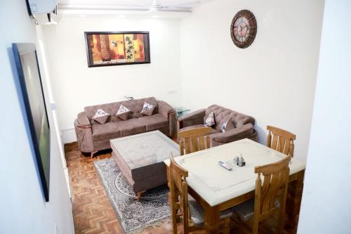 a living room with a couch and a table and chairs at Fortune Home Service Apartment 3Bhk,E-28 Saket 1B in New Delhi
